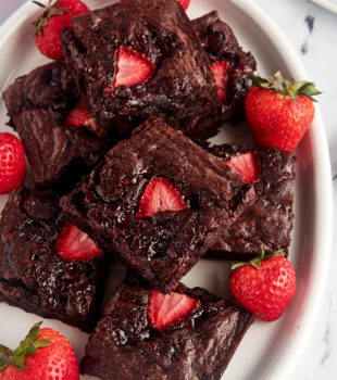 Overhead view of strawberry brownies on platter with fresh berries