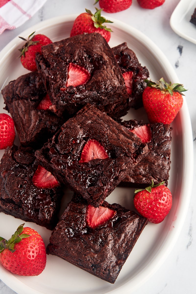 Overhead view of strawberry brownies on platter with fresh berries