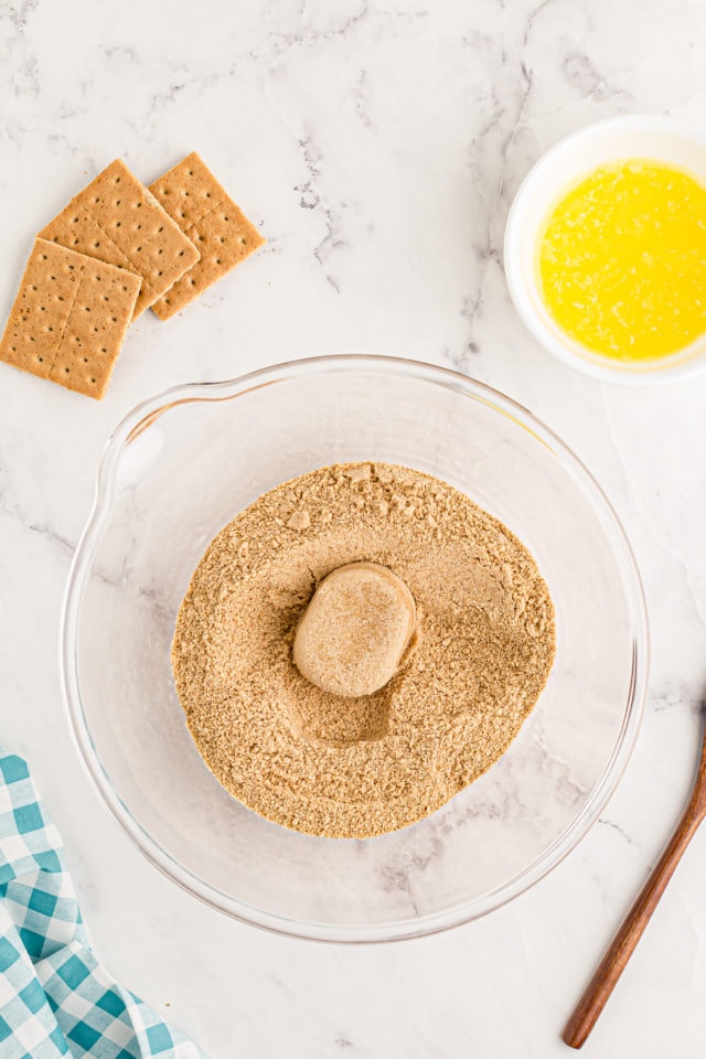 Overhead view of graham cracker crumbs and brown sugar in mixing bowl