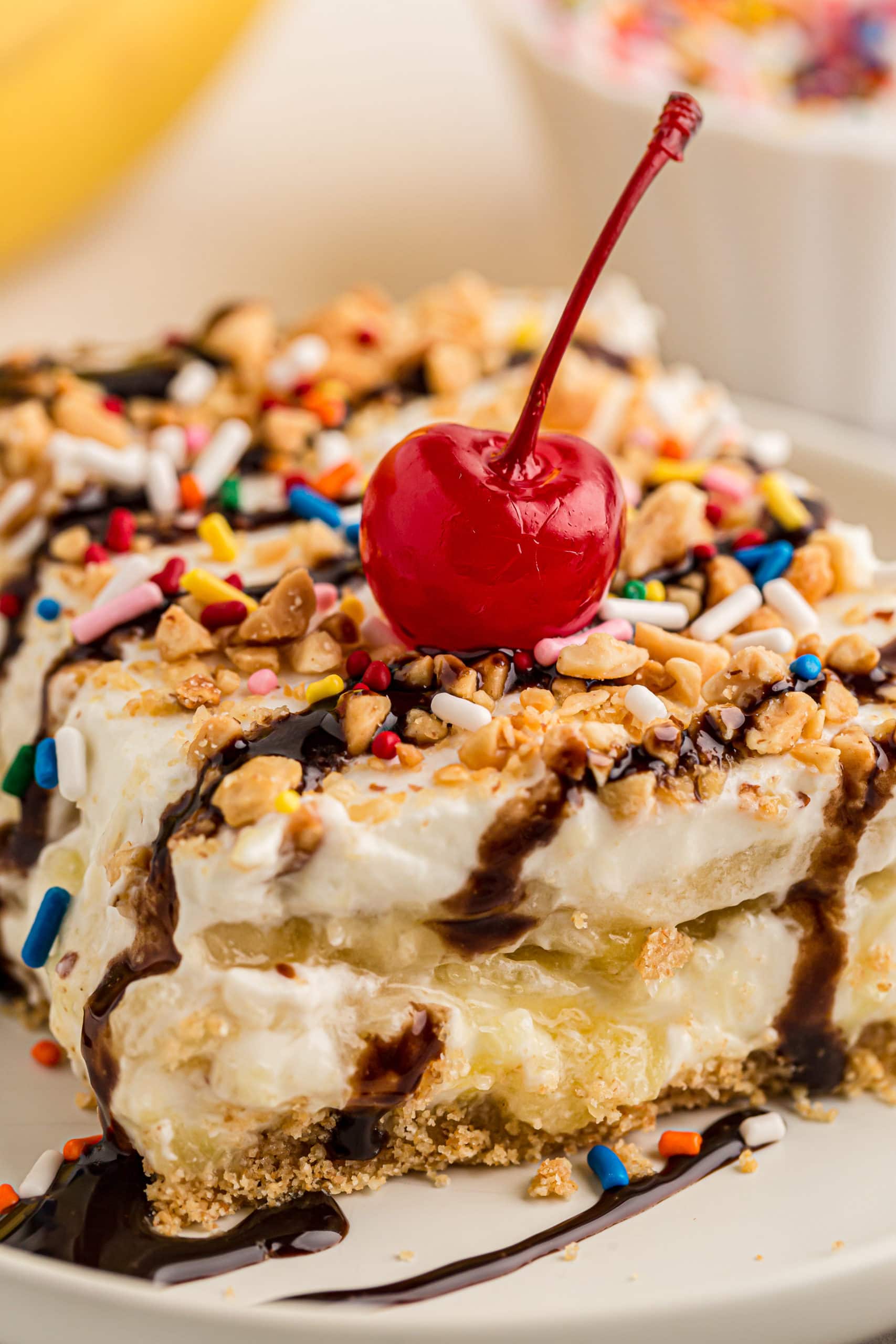 Closeup of banana split cake topped with cherry