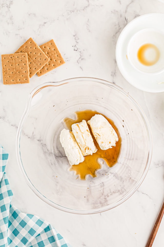 Overhead view of cream cheese and vanilla in mixing bowl