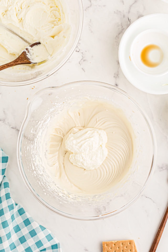 Overhead view of whipped cream added to cream cheese mixture for banana split cake