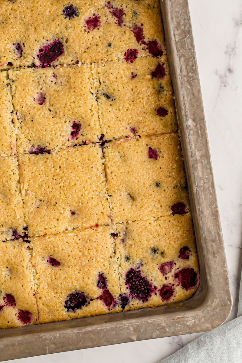 overhead view of sliced berry pudding cake in a metal baking pan