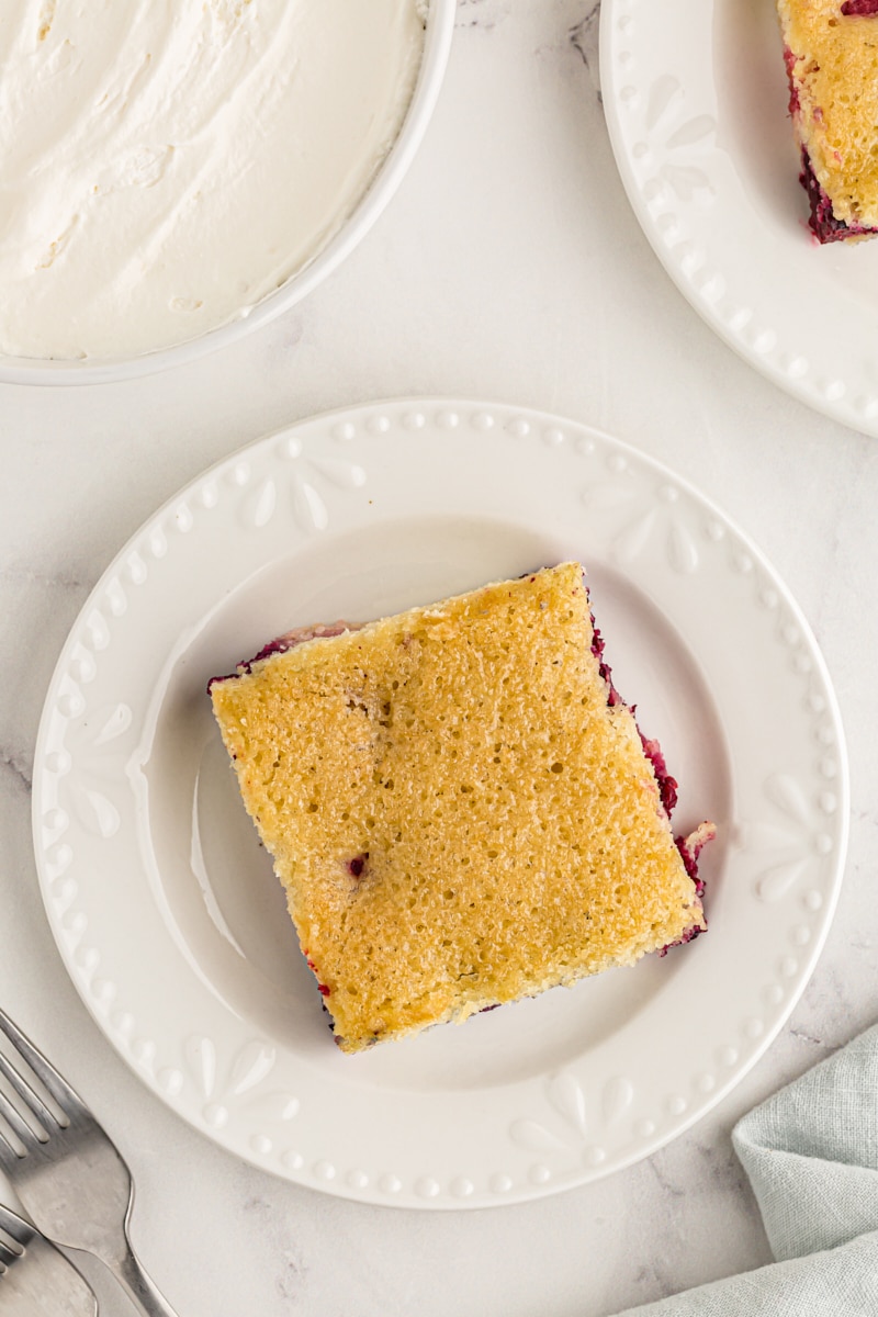 overhead view of a slice of berry pudding cake on a white plate