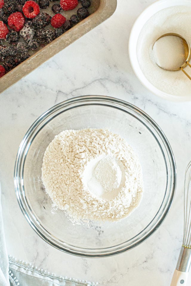 overhead view of flour, baking powder, and salt in a glass mixing bowl