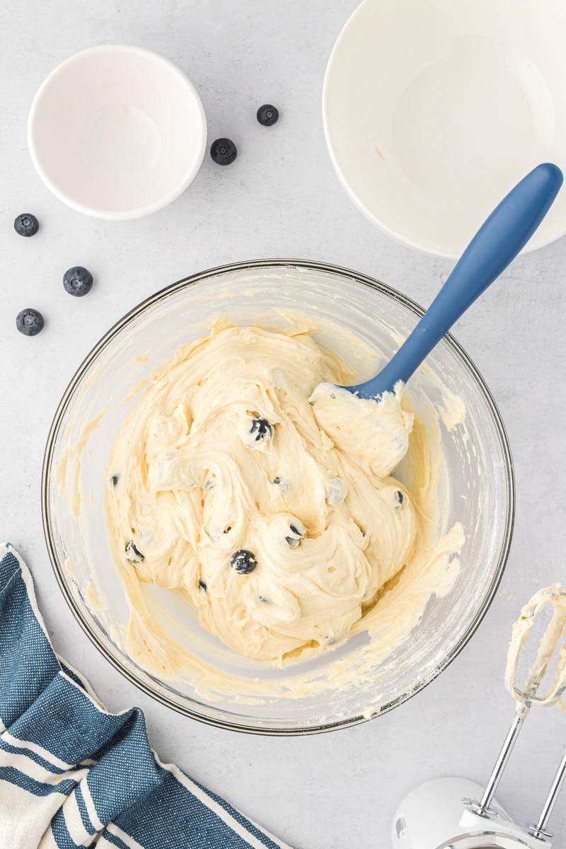 overhead view of mixed lemon blueberry cookie dough in a glass mixing bowl