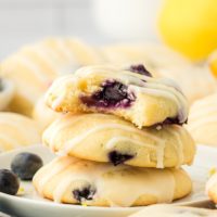 a stack of three lemon blueberry cookies with a bite missing from the top cookie