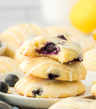 a stack of three lemon blueberry cookies with a bite missing from the top cookie