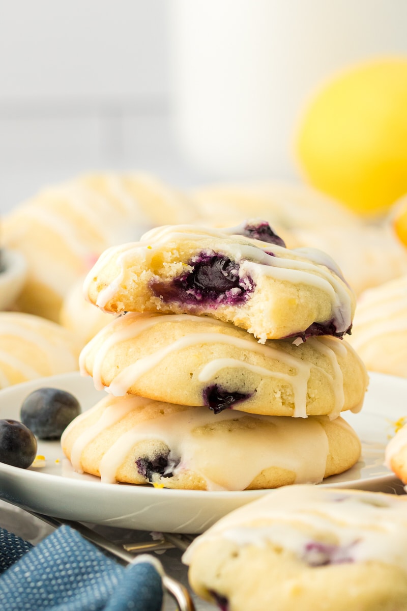 a stack of three lemon blueberry cookies with a bite missing from the top cookie