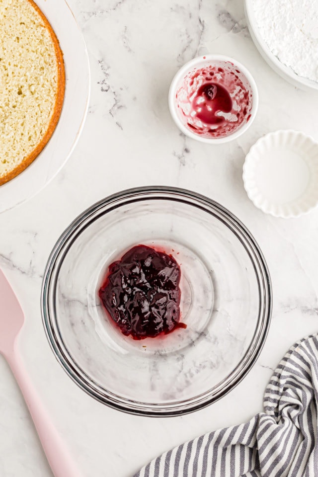 Overhead view of raspberry jam and water in glass bowl