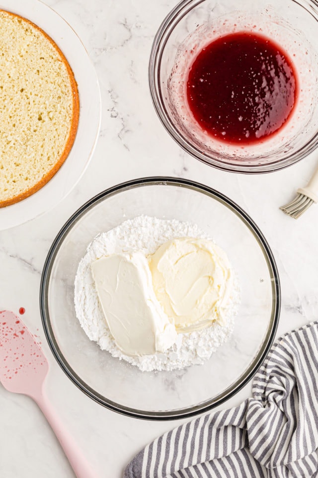 Overhead view of powdered sugar, mascarpone, and cream cheese in mixing bowl before combining