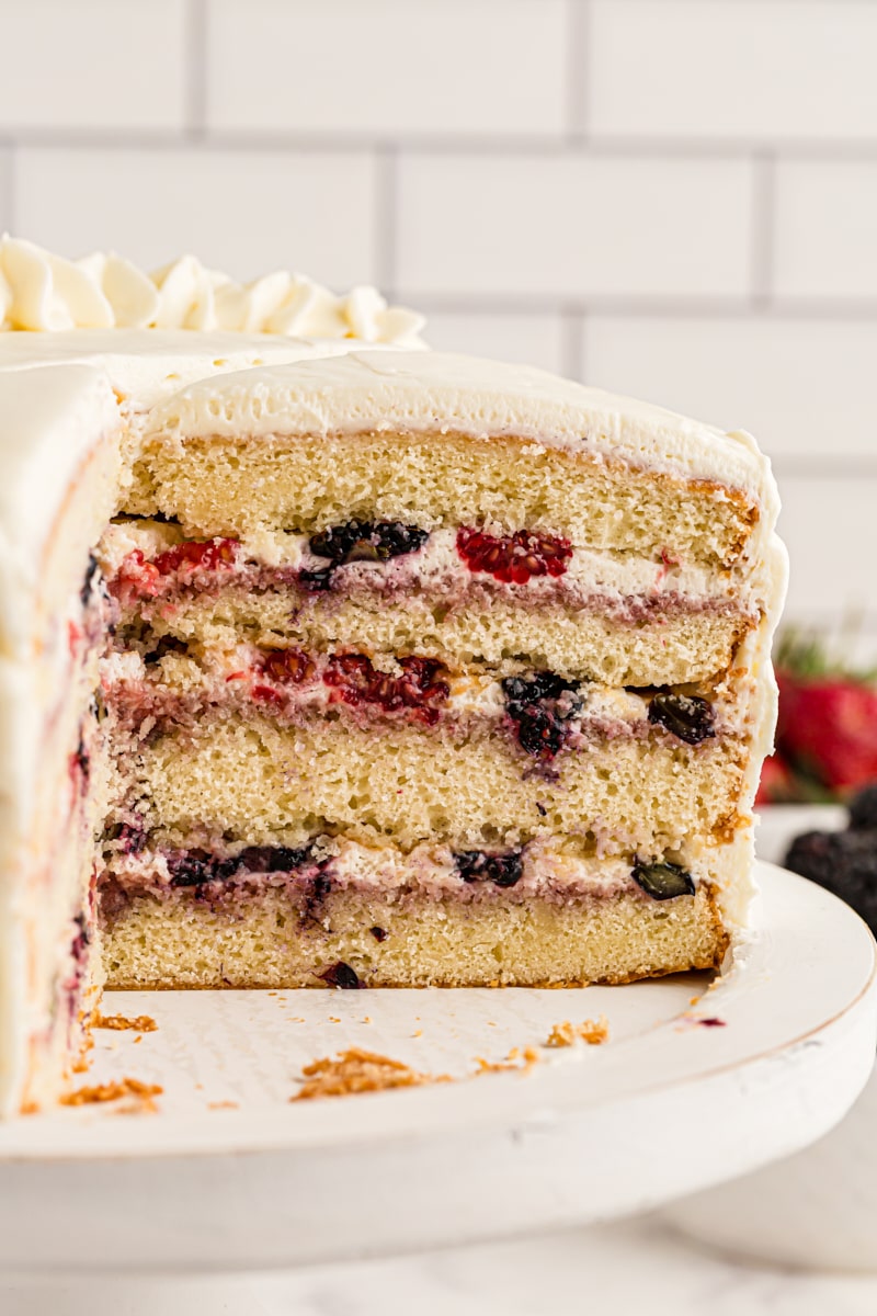 Chantilly cake on cake stand with slices removed to show layers