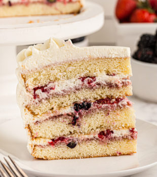 Side view of chantilly cake slice on plate, showing 4 cake layers