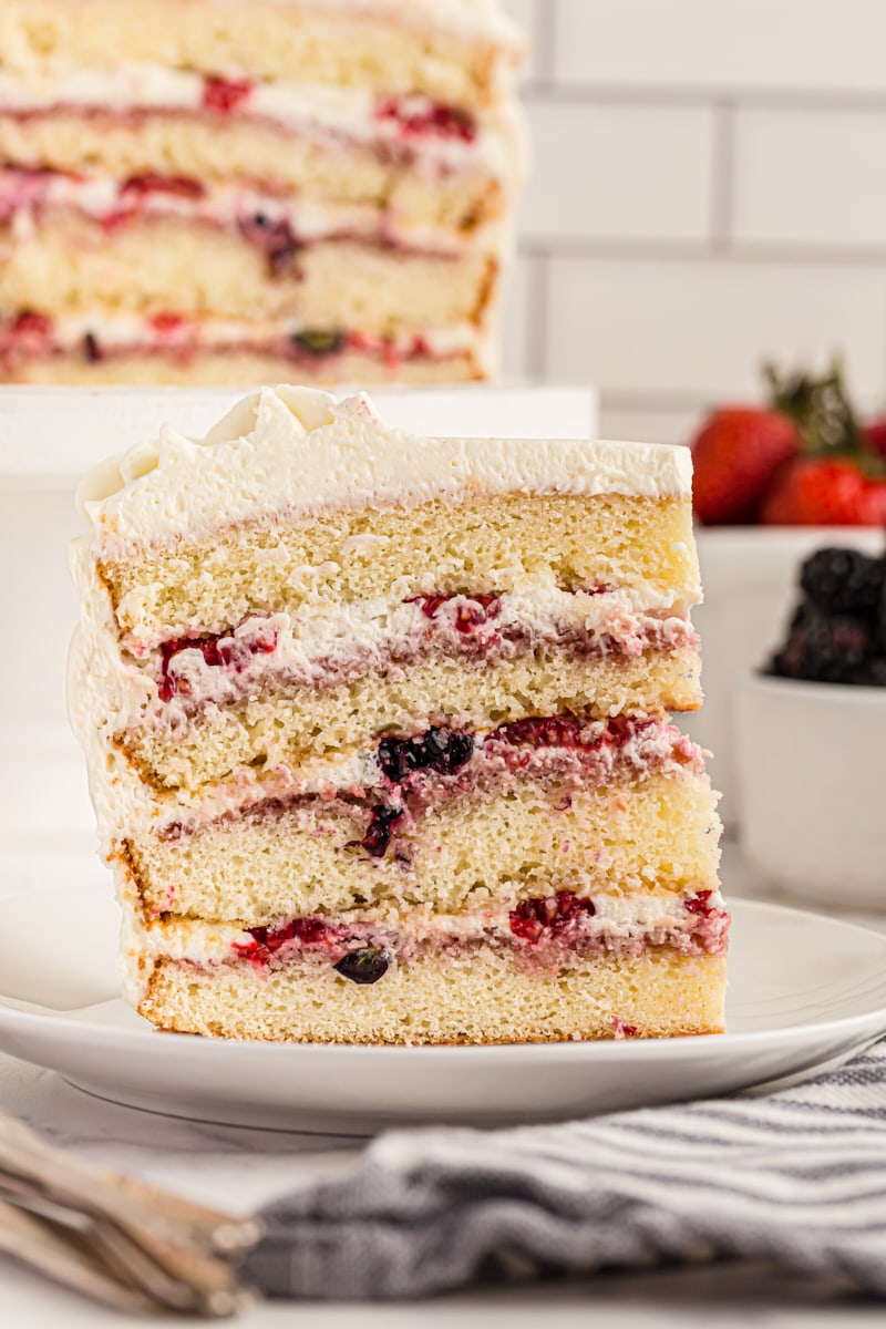 Side view of chantilly cake slice on plate, showing 4 cake layers