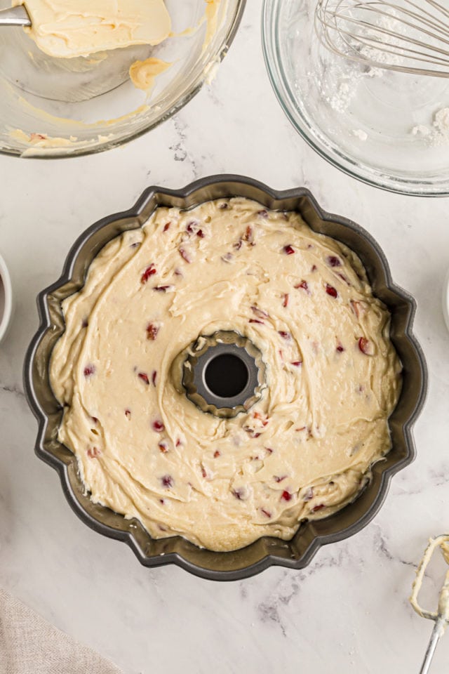 Overhead view of cherry cake batter in Bundt pan