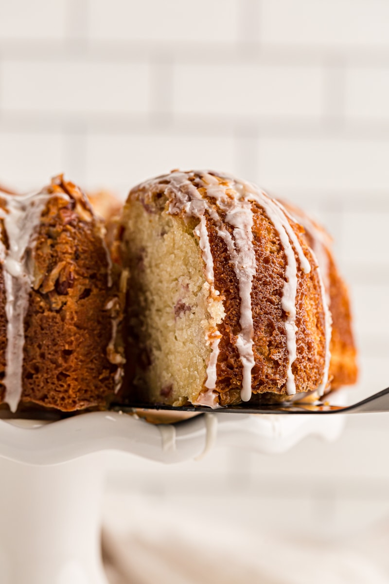 Removing slice of cherry-vanilla yogurt cake from cake stand