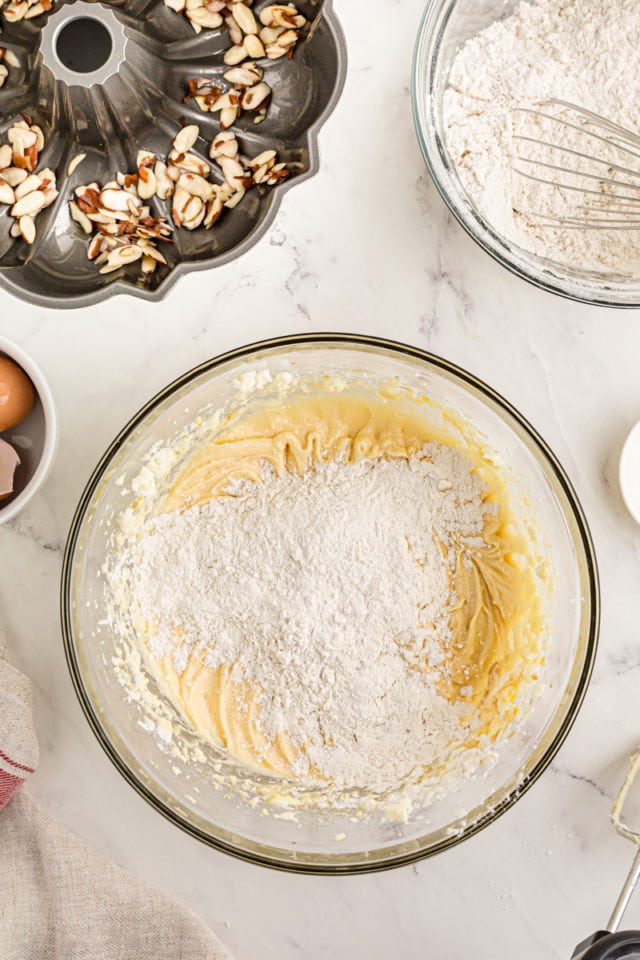 Overhead view of dry ingredients added to bowl of cake batter