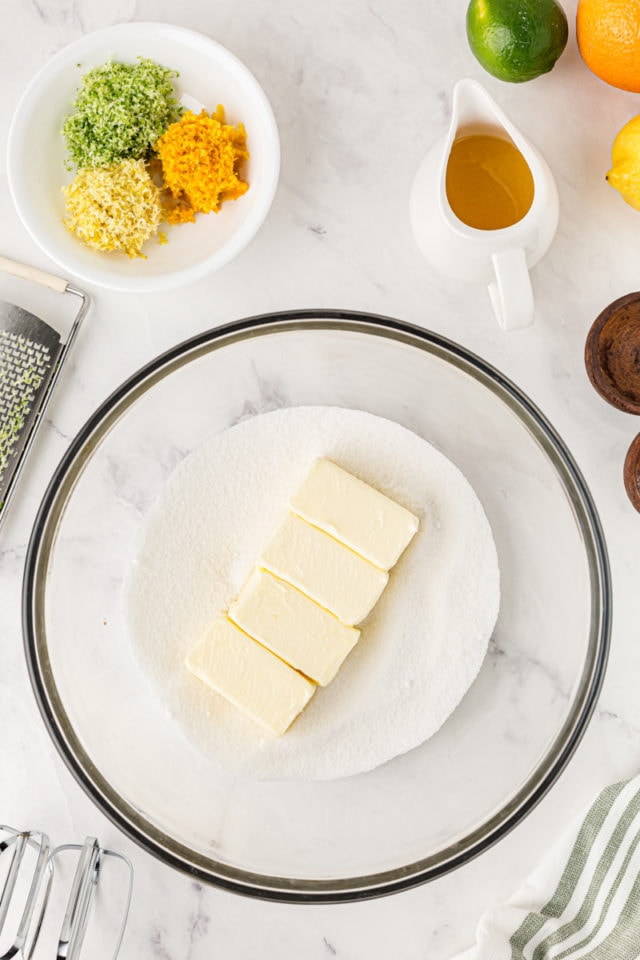 overhead view of butter and sugar in a glass mixing bowl