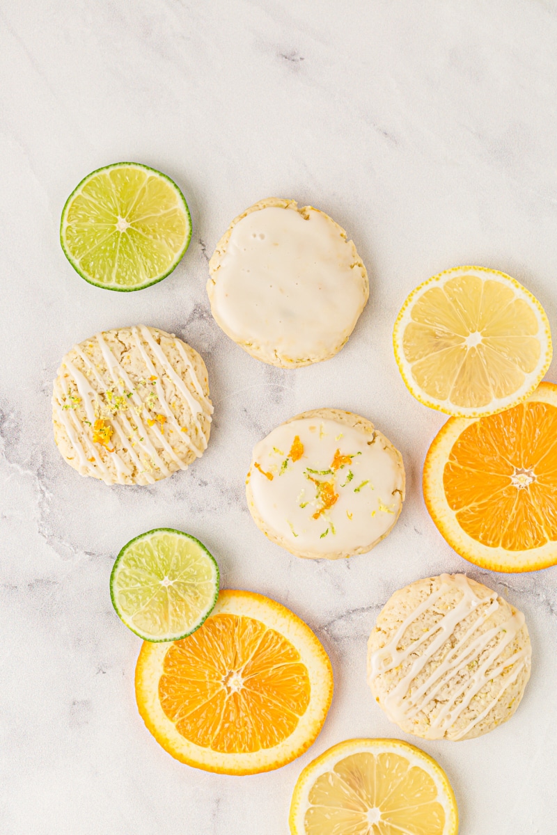 overhead view of Triple Citrus Cookies and lemon, lime, and orange slices on a marble surface