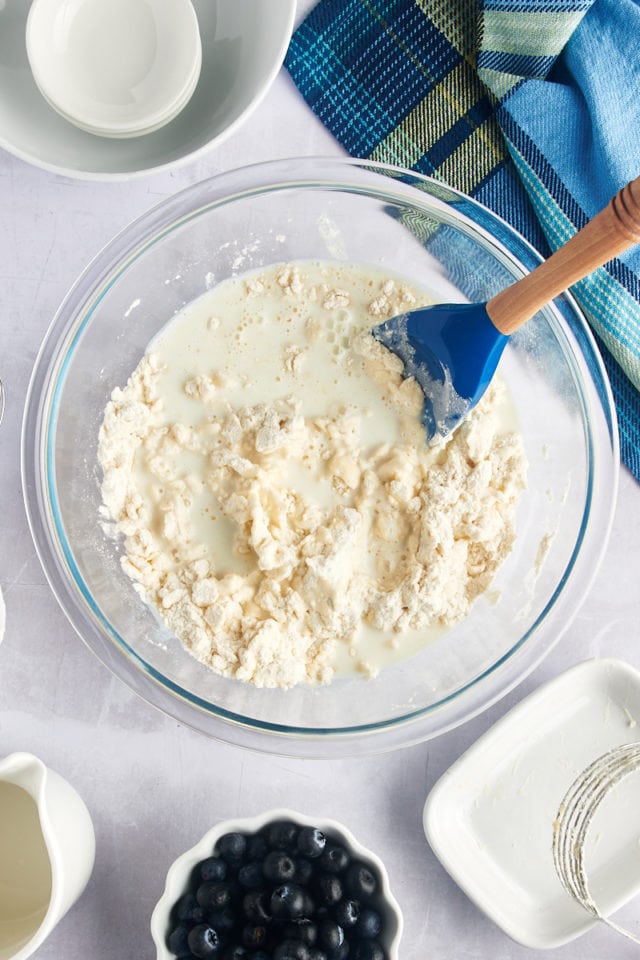 Overhead view of milk added to bowl of biscuit dough