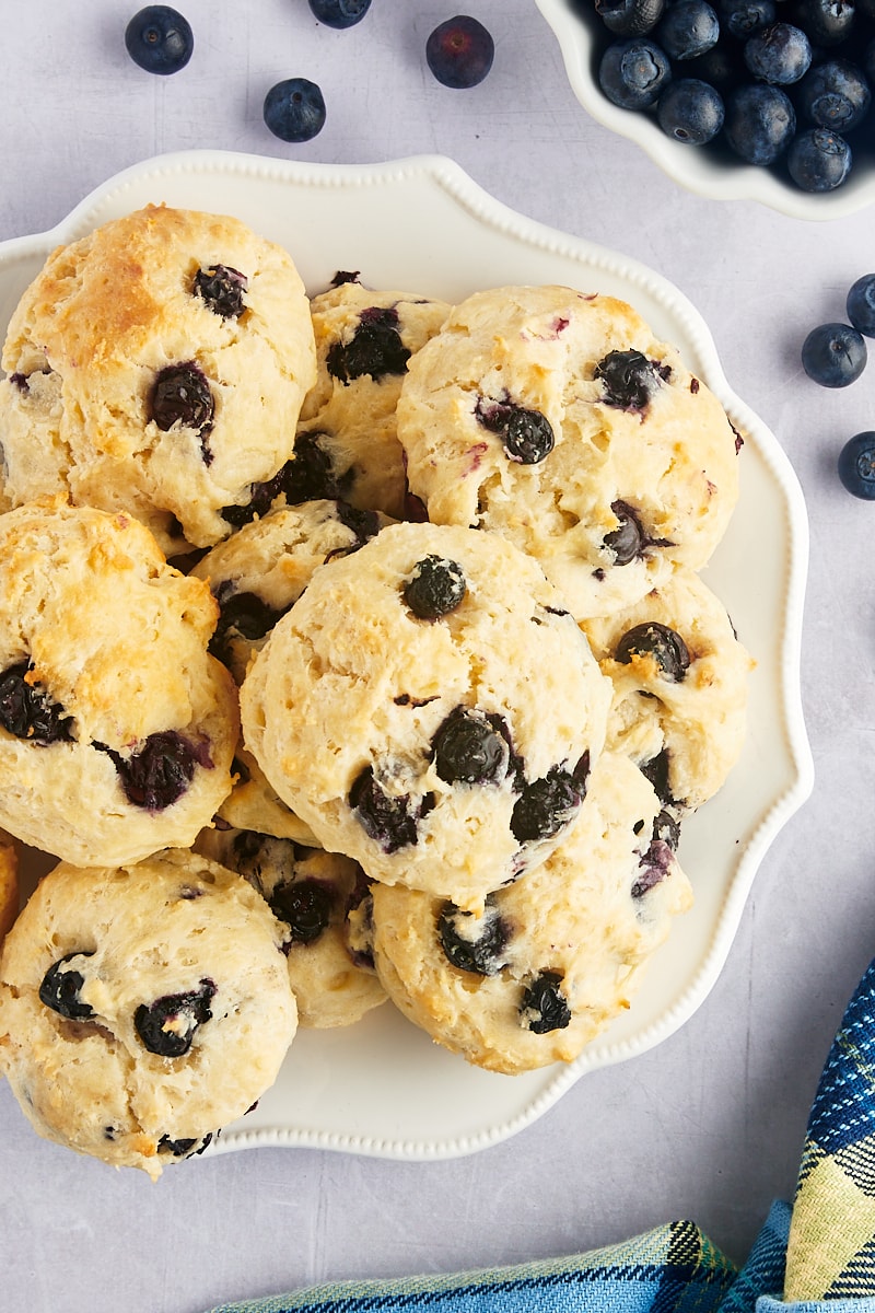 Overhead view of blueberry drop biscuits stacked on plate