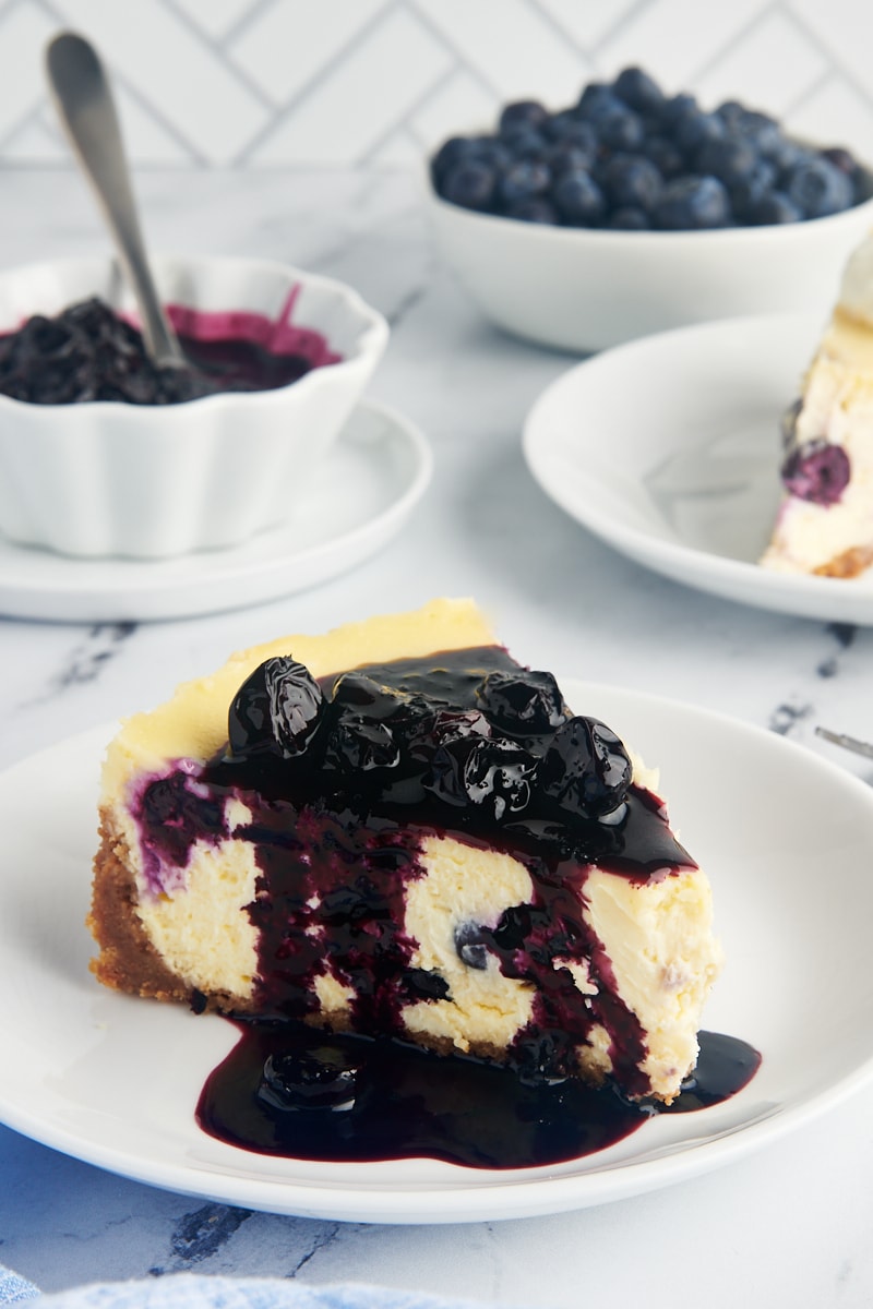 a slice of blueberry cheesecake topped with blueberry compote