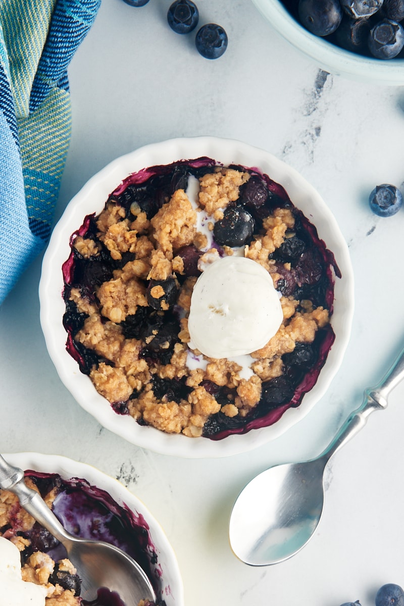 Overhead view of blueberry crumble topped with scoop of vanilla ice cream