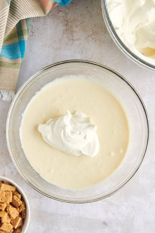 Overhead view of whipped cream added to cheesecake mixture