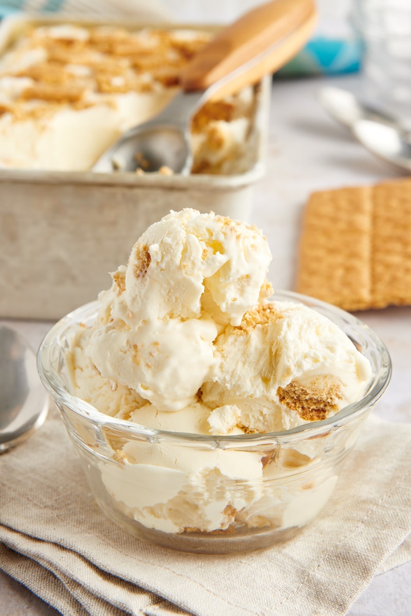 Bowl of cheesecake ice cream with loaf pan of ice cream in background