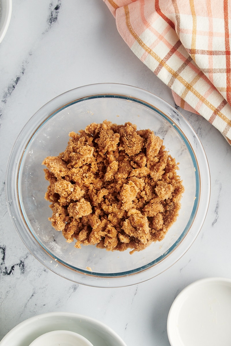 Close-up of a perfectly mixed crumb topping, showing distinct buttery crumbs, in a glass mixing bowl.