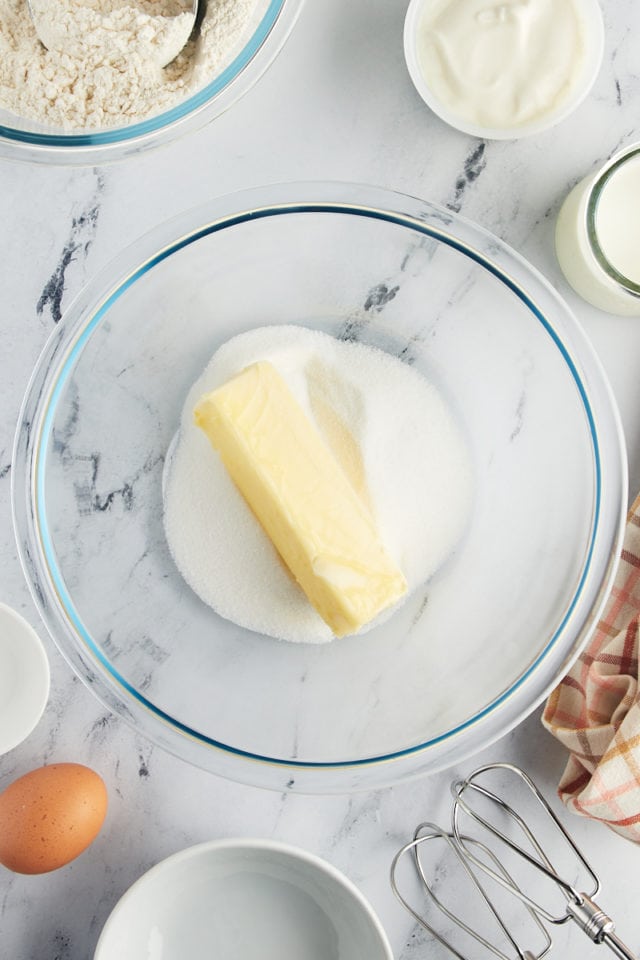 overhead view of butter and sugar in a glass mixing bowl