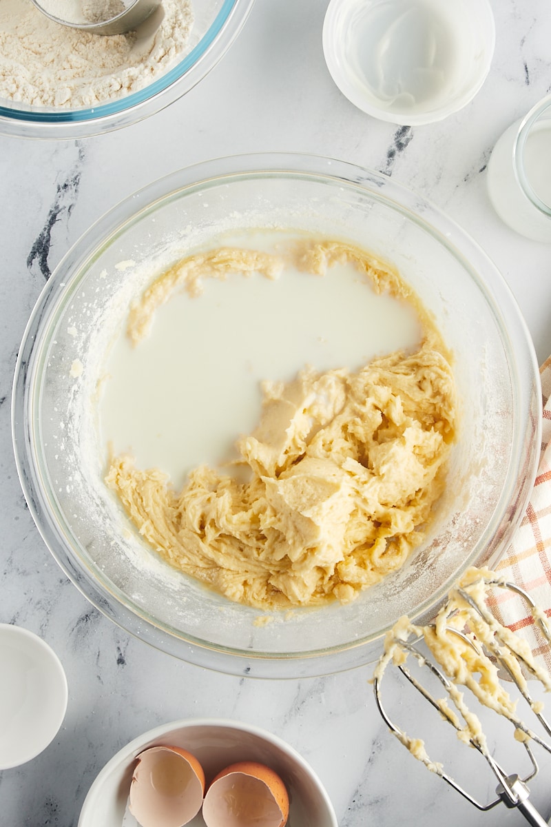Milk being gently poured into the developing cake batter.