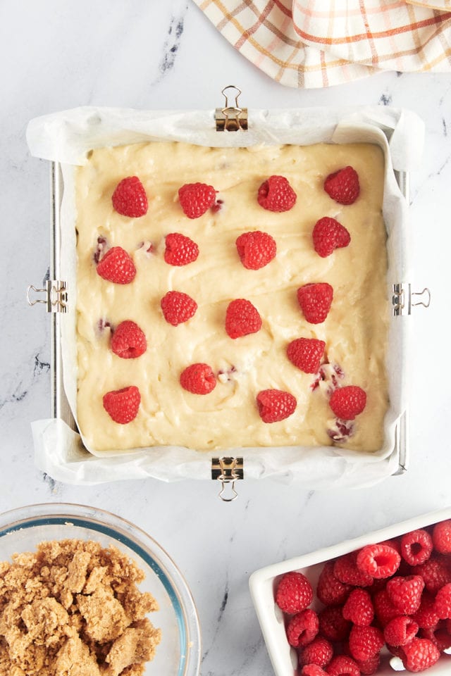 overhead view of raspberries scattered over raspberry coffee cake batter