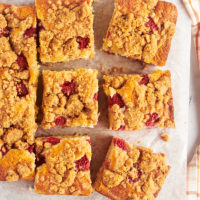 overhead view of slices of raspberry coffee cake on parchment paper