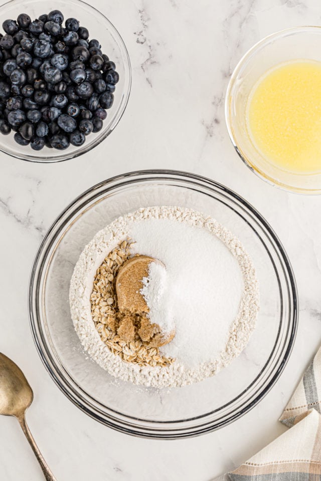 Overhead view of dry ingredients for crust in glass bowl