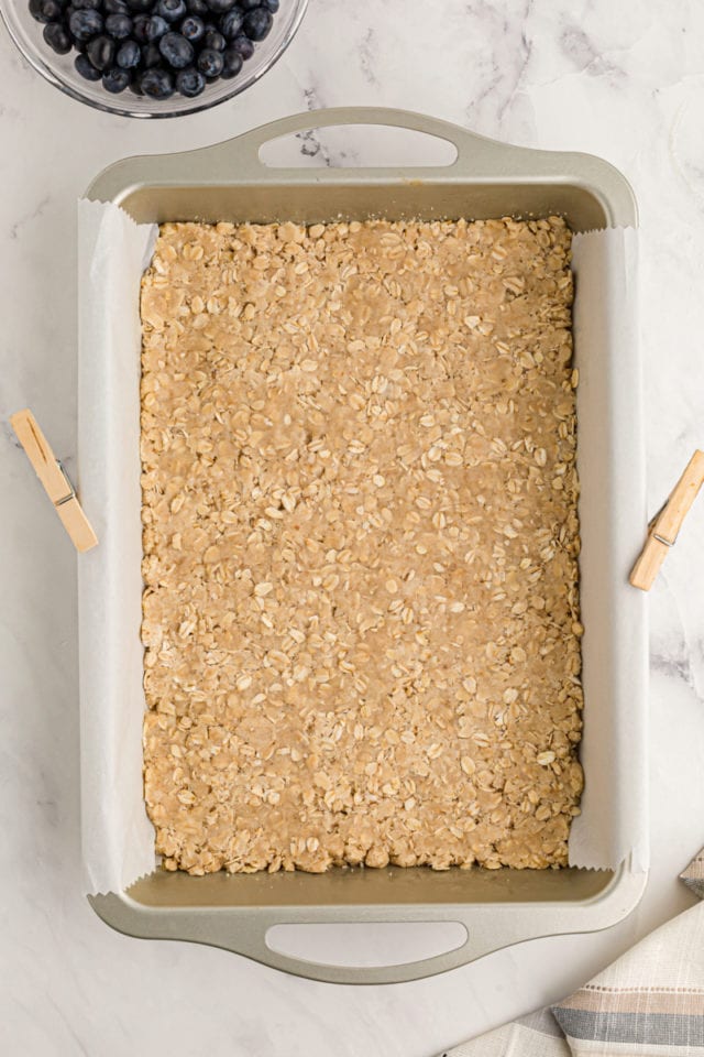 Overhead view of crust for cheesecake bars in pan