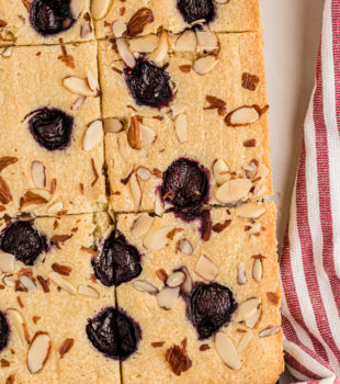 Overhead view of cherry almond sheet cake cut into pieces