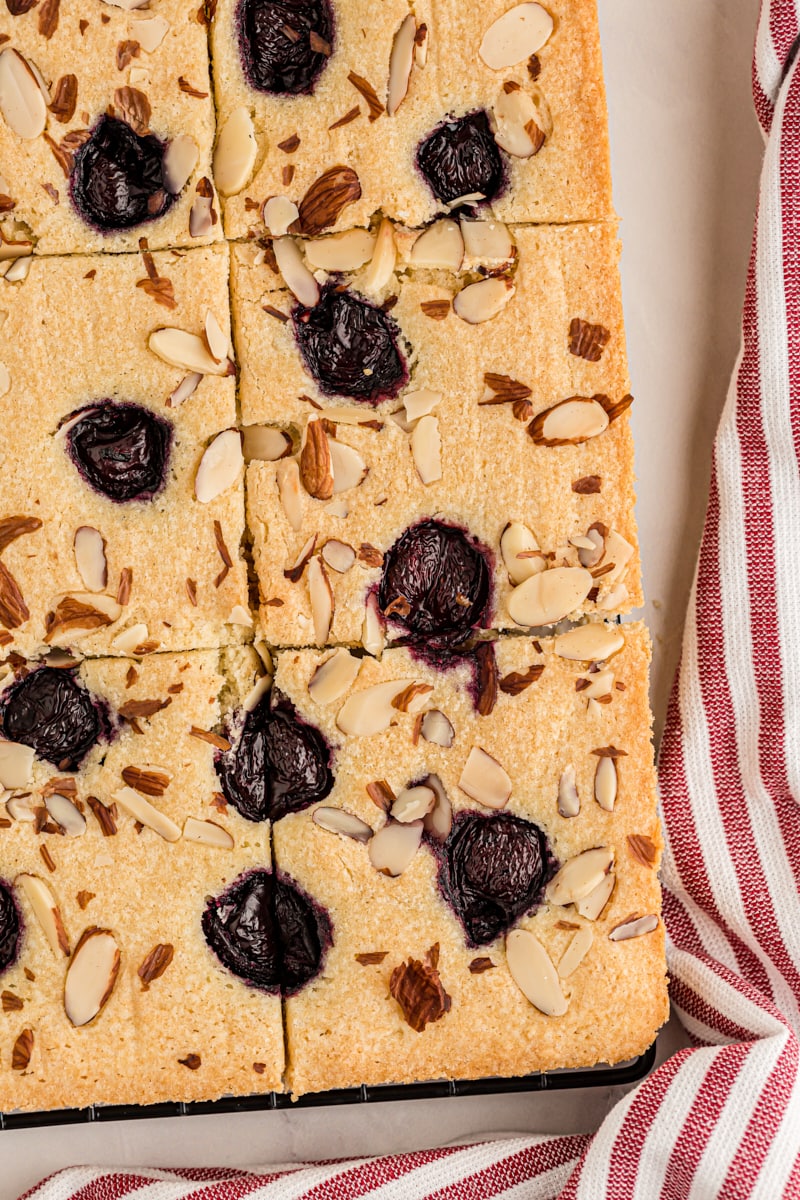 Overhead view of cherry almond sheet cake cut into pieces