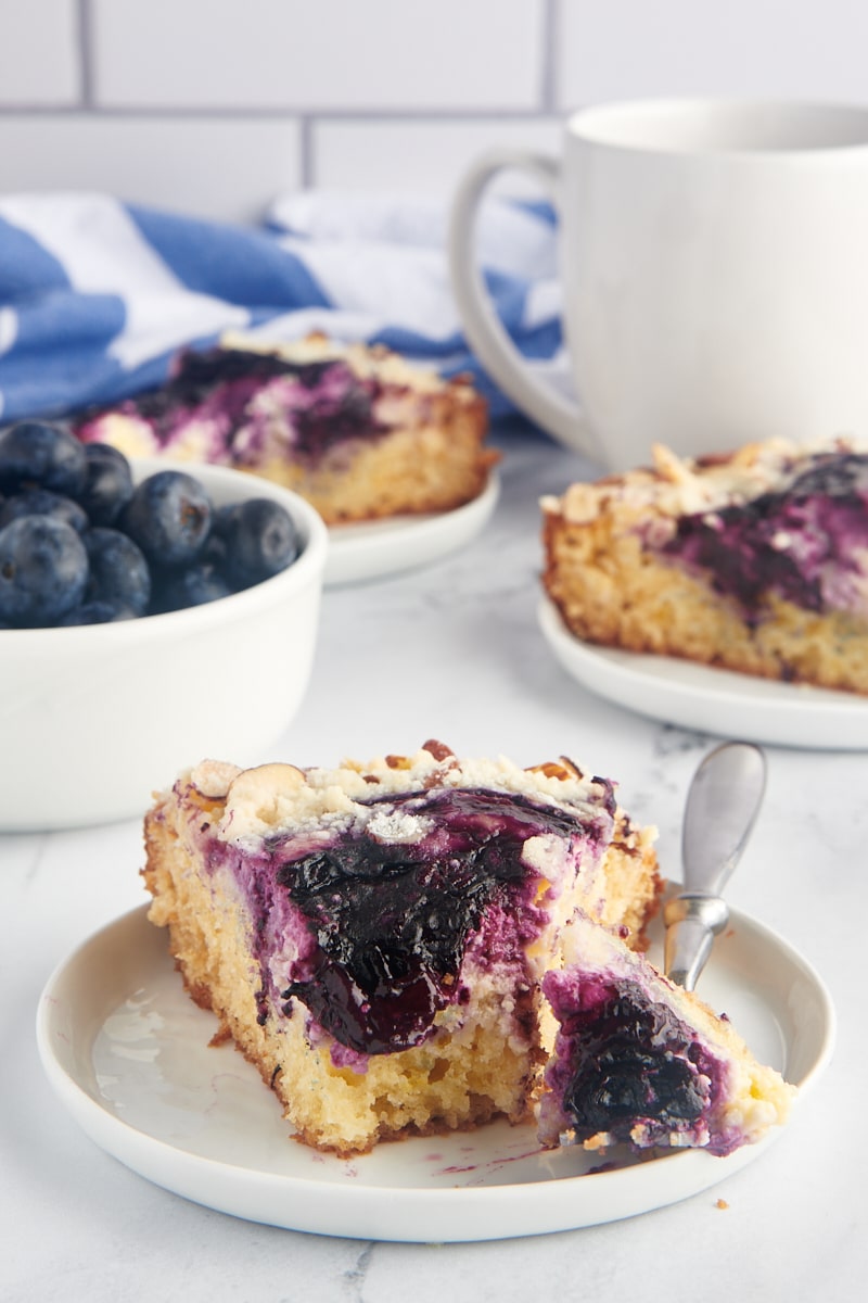 Slice of blueberry cream cheese coffee cake on plate with fork
