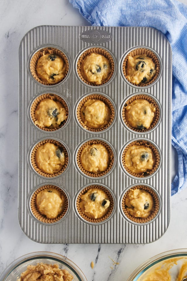 Overhead view of blueberry crumb muffins in pan before adding crumbs