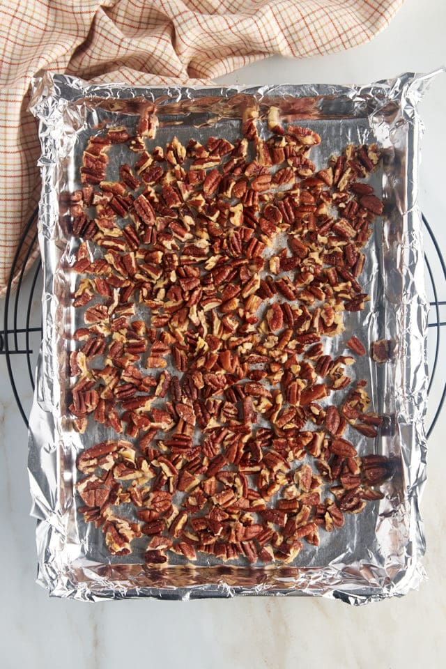 overhead view of toasted pecans on a foil-lined baking sheet