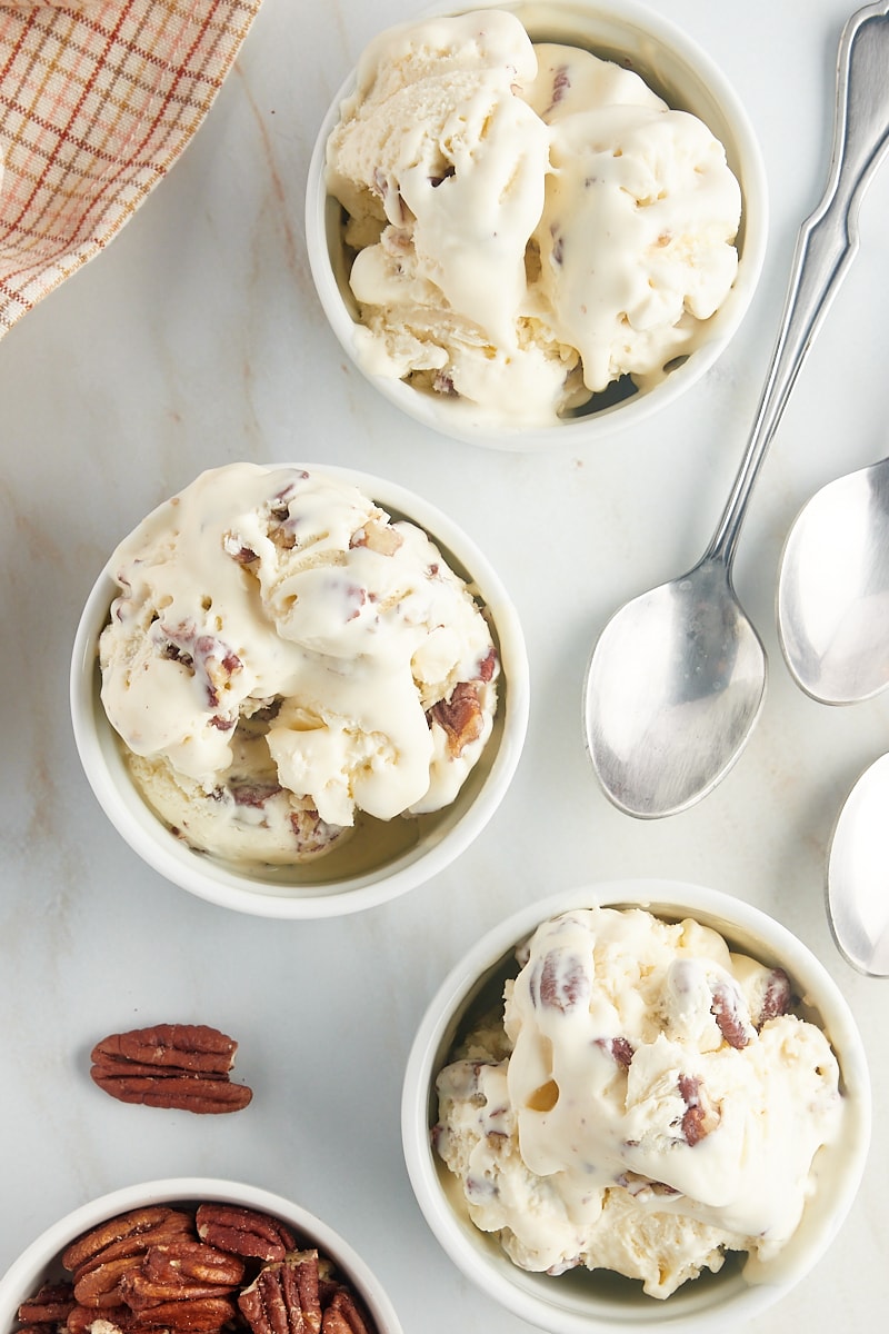 overhead view of three servings of butter pecan ice cream served in white ramekins
