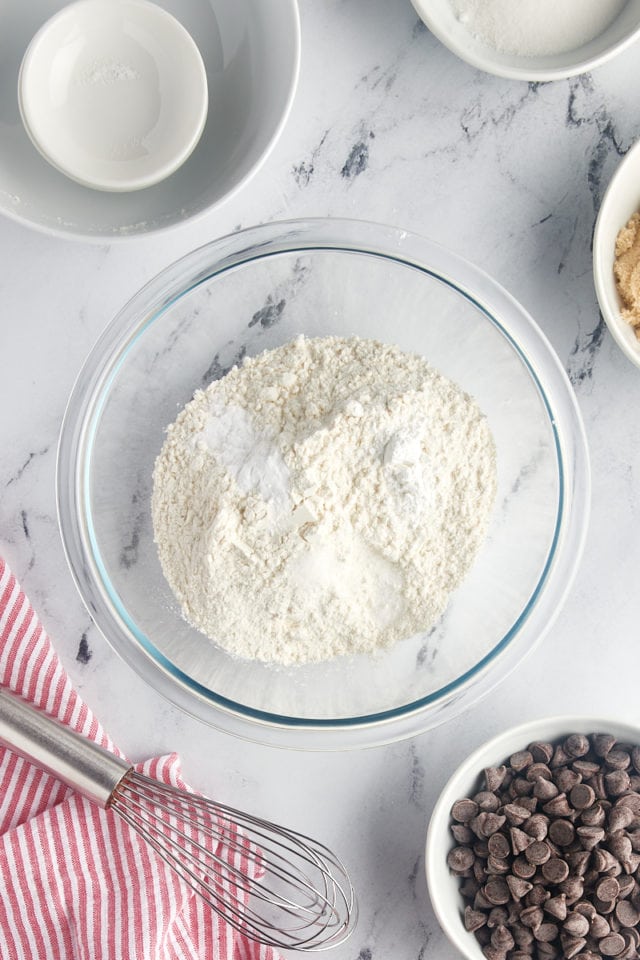 overhead view of flour, cornstarch, baking soda, and salt in a glass mixing bowl