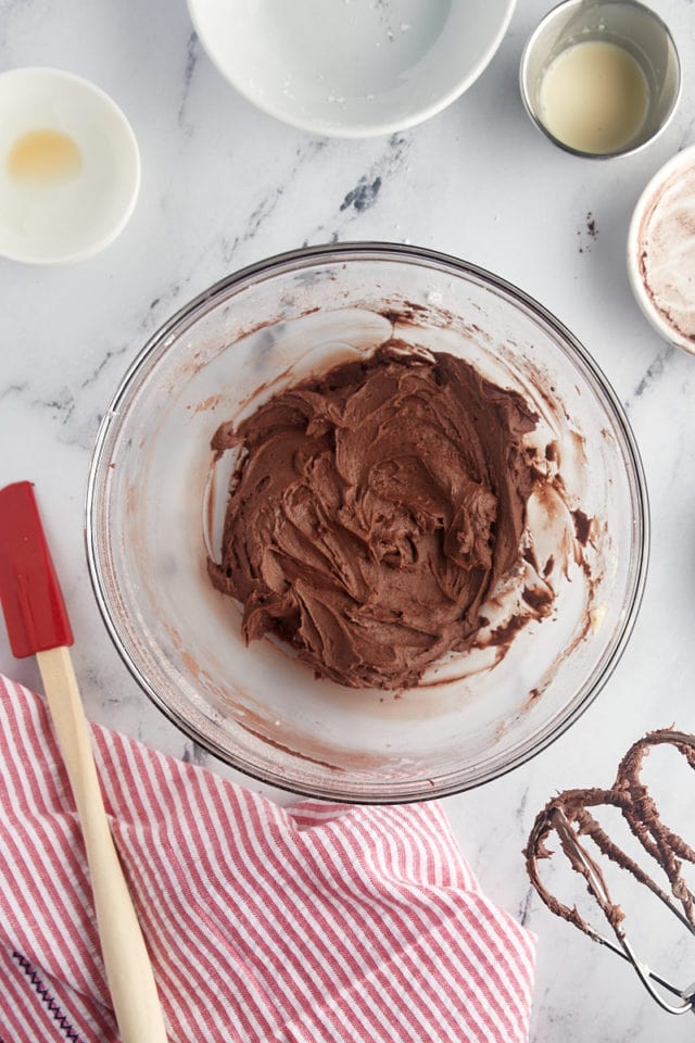 overhead view of chocolate buttercream in a glass mixing bowl