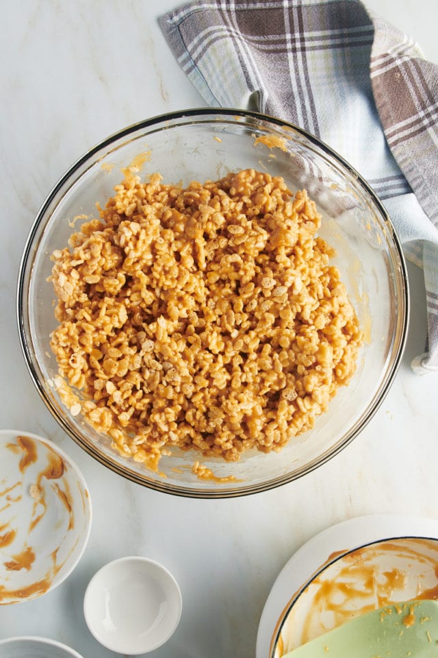 Overhead view of peanut butter and crispy rice mixture in glass bowl