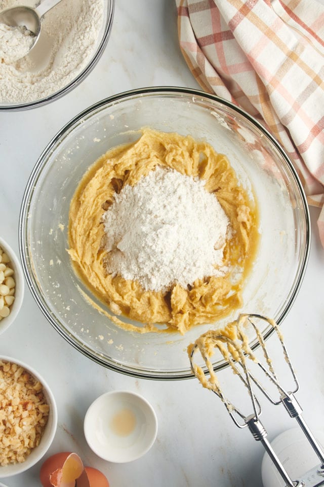 Overhead view of flour added to wet ingredients for cookies.