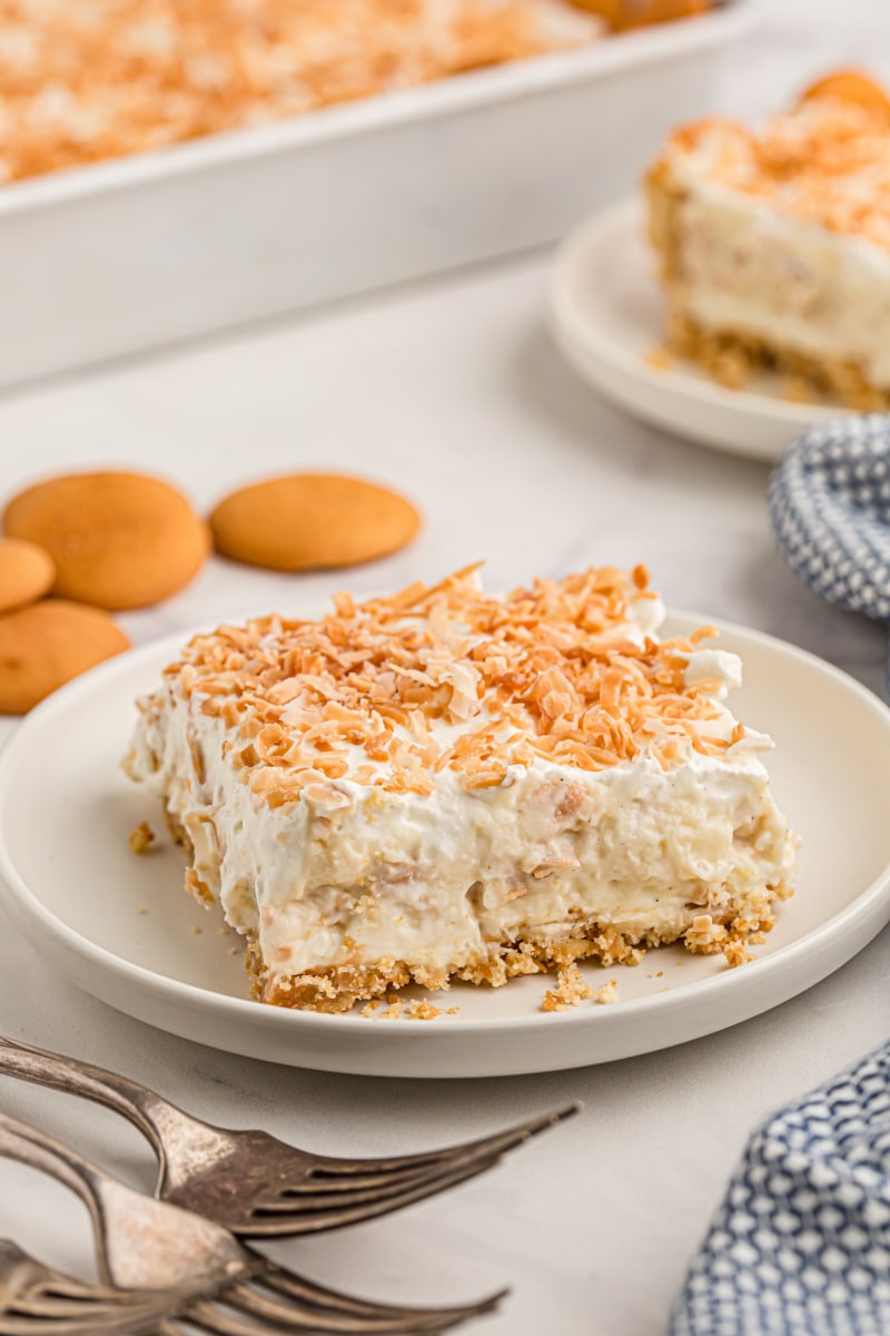 Coconut cream pie bar on plate with toasted coconut on top