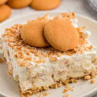 Coconut cream pie bar on plate with vanilla wafers on top for garnish