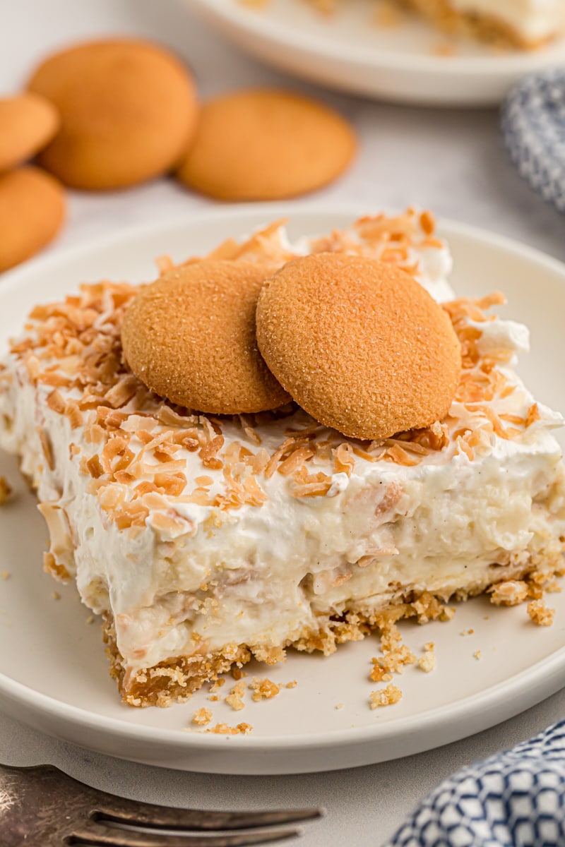 Coconut cream pie bar on plate with vanilla wafers on top for garnish