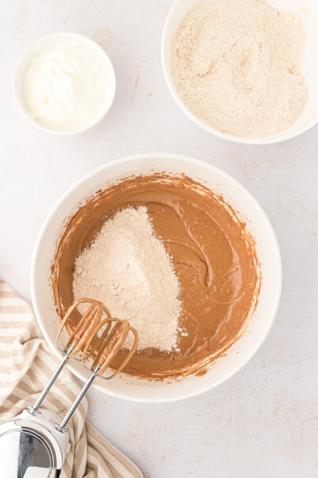 Overhead view of dry ingredients added to chocolate hazelnut cake batter